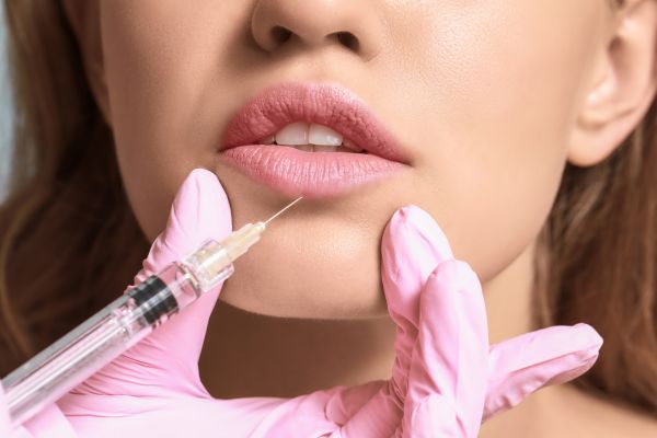 Lip enhancement Newport - Close up photo of a woman's face. She is receiving a lip enhancement injection