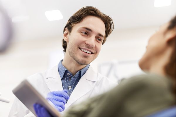 general dentistry in Shropshire - Photo of a dentist standing next to a dental patient.